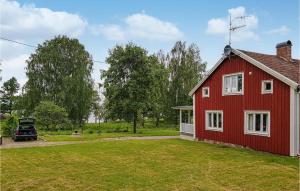 une maison rouge avec une voiture garée devant elle dans l'établissement 3 Bedroom Awesome Home In Vxj, à Växjö