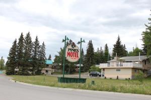 una señal para un motel de pino al lado de una carretera en Pines Motel, en Hinton