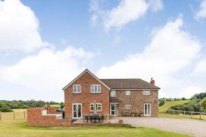 a brick house with a table in front of it at Wood Cottage in Tenbury