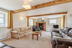 a living room with a couch and a table at Wood Cottage in Tenbury