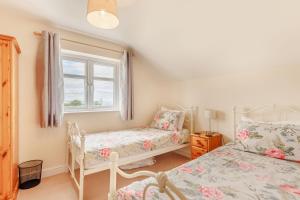 a bedroom with two beds and a window at Wood Cottage in Tenbury