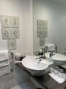 um banheiro branco com uma pia e um espelho em Nice Hotel em New Plymouth