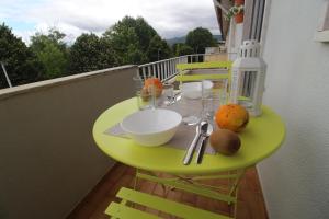 una mesa verde en un balcón con comida. en Retorta do Pico - Alojamento Local, en Caminha