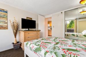 a bedroom with a bed and a flat screen tv at The Bamboo Oasis at Bamboo Waikiki #307 in Honolulu +39 photos