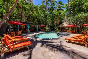 a swimming pool with lounge chairs and a resort at The Bamboo Oasis at Bamboo Waikiki #307 in Honolulu