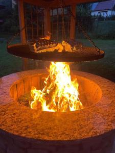 a fire pit with a swing above it with fire at Domek pod Kłódką in Kamesznica