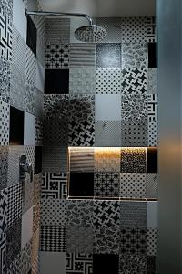 a bathroom with a shower with black and white tiles at Casa Crónica in Oaxaca City +169 photos