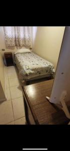 a small room with a bed and a table with a table sidx sidx at La casa de Ely in Iquique