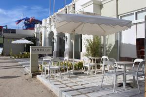 長灘島的住宿－長灘島金沙酒店，一组桌子和椅子,放在伞下