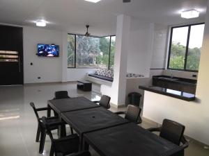 comedor con mesas y sillas y TV en VILLA SAMARI 2 Casa campestre con piscina privada en Girardot