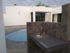 uma cozinha com um lavatório e uma piscina em VILLA SAMARI 2 Casa campestre con piscina privada em Girardot
