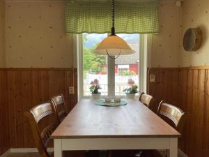 a dining room table with chairs and a large window at Holiday home EVERÖD in Everöd