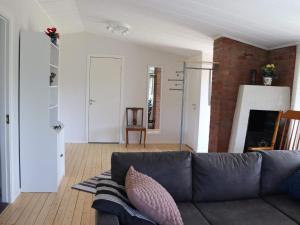 a living room with a couch and a brick wall at 5 person holiday home in TRÄSLÖVSLÄGE-By Traum in TrÃ¤slÃ¶vslÃ¤ge