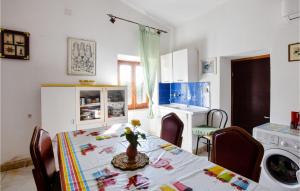 a dining room with a table and a kitchen at 1 Bedroom Stunning Home In Nulvi in Nulvi