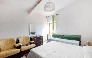 a bedroom with a bed and a chair at 1 Bedroom Stunning Home In Nulvi in Nulvi