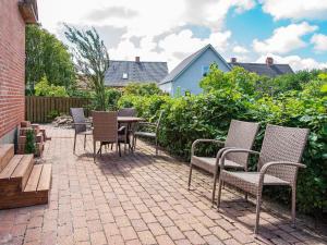 a patio with chairs and a table and a bench at 10 person holiday home in Ulfborg-By Traum in Ulfborg