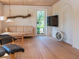 a living room with a couch and a flat screen tv at 10 person holiday home in Ulfborg-By Traum in Ulfborg