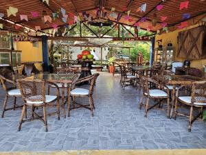 a restaurant with wooden tables and chairs and a room with tables and chairsktop at Pousada Beach Bahia in Porto Seguro