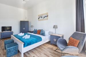 een slaapkamer met een bed met blauwe lakens en een stoel bij Familien Ferienwohnung Haus Waldeck in Bad Elster