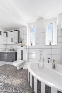 a white bathroom with a tub and a sink at Familien Ferienwohnung Haus Waldeck in Bad Elster