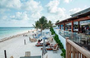 a beach with people sitting on the sand at Casa Jaguar in Puerto Morelos