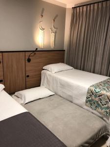 a bedroom with two beds and two antlers on the wall at B14 Suítes in Penha