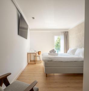 a white bedroom with a bed and a window at Hotel Boutique Berazadi Berri in Zarautz