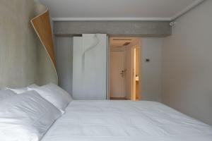 a bedroom with a white bed and an open door at Hotel Boutique Berazadi Berri in Zarautz