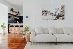 sala de estar con sofá blanco y cocina en Soul, en Byron Bay