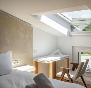 a bedroom with a bed and a window and a chair at Hotel Boutique Berazadi Berri in Zarautz