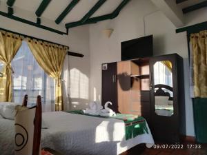 a bedroom with a bed with a mirror and a tv at CASA VILLA LUGUIANGA Villa de Leyva in Villa de Leyva