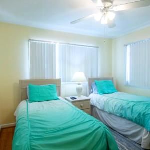 een slaapkamer met 2 bedden en een plafondventilator bij Vacation Home With Pool in siesta key sarasota in Siesta Key