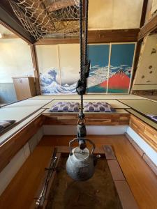 un pot suspendu à une chaîne dans un bateau dans l'établissement ゲストハウス餓鬼大将, à Omachi