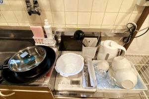 a kitchen counter with dishes and utensils at ラ・ポート空港前107 in Shime