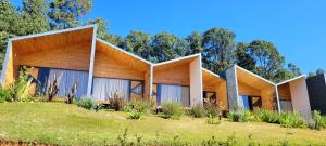 uma casa num campo com árvores ao fundo em Hotel Pico 16 em Monte Verde