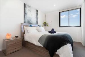 um quarto com uma cama grande e uma janela em Inner city 1 bedroom Apartment with Rooftop pool and Parking - Serain Residences em Brisbane