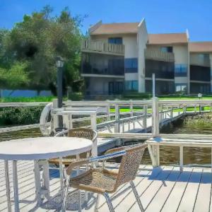 a table and chairs on a deck in front of a building at Sarasota Pool Apartment in Siesta Key