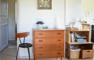 - une commode en bois dans une chambre avec une chaise dans l'établissement Lovely Home In Oskarshamn With House Sea View, à Oskarshamn