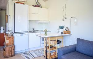 a kitchen with white cabinets and a blue couch at 2 Bedroom Stunning Home In Oskarshamn in Oskarshamn
