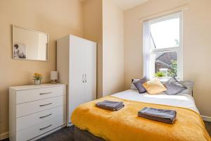 a bedroom with a bed with a dresser and a window at Ursula Sparkle Stays in Liverpool