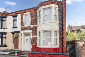 a red brick house with a white door at Ursula Sparkle Stays in Liverpool