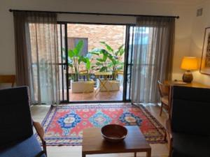 una sala de estar con una gran puerta corredera de cristal en West End District Apartments en Fremantle