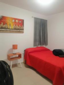 a bedroom with a red bed and a night stand at hermosa casa en coto privado especialmente para ti 
