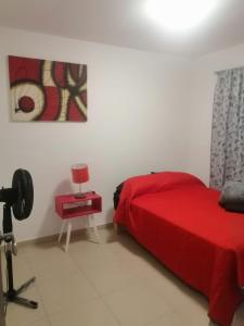ein Schlafzimmer mit einem roten Bett und einer Kamera in der Unterkunft hermosa casa en coto privado especialmente para ti 