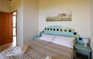 een slaapkamer met een bed en een schilderij aan de muur bij Pet Friendly Apartment In Zambrone With Kitchen in Zambrone