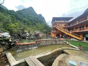 a building with a waterfall next to a river at HOMESTAY PAC BO CAO BẰNG in Cao Bằng