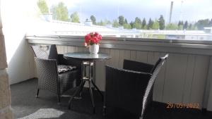 einen Tisch mit Stühlen und eine Vase mit Blumen auf dem Balkon in der Unterkunft Gasthouse Oulu in Oulu