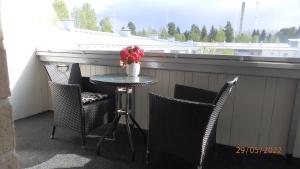 a table with chairs and a vase of flowers on a balcony at Gasthouse Oulu in Oulu