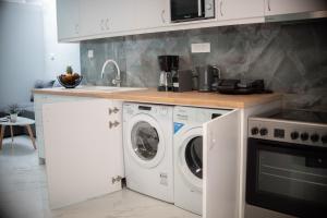 uma cozinha com uma máquina de lavar roupa e um lavatório em John's Minimal Loft em Agios Nikolaos