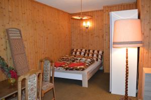 een slaapkamer met een bed, een tafel en een lamp bij Apartman Kammleitn in Hermagor